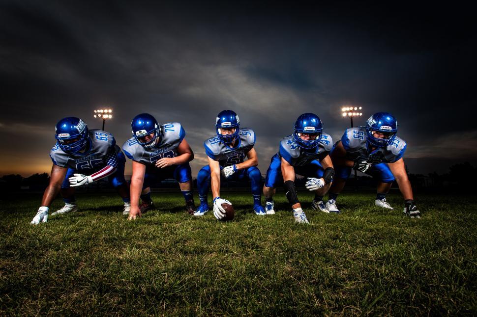 football-players-in-lineup-with-night-time-stadium-lights