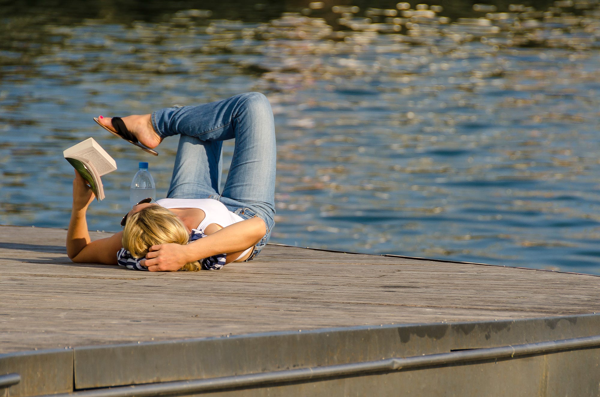 woman-reading-book-on-end-of-pier