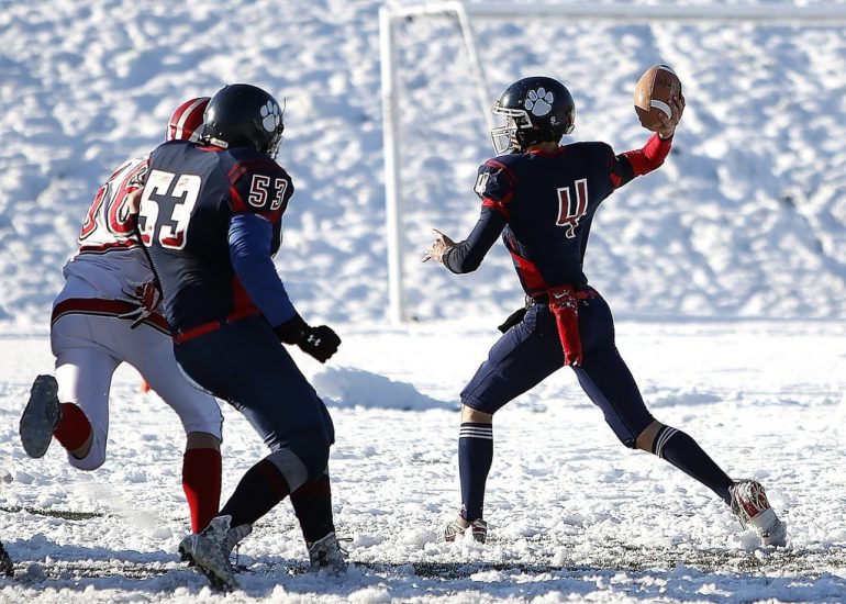 american-football-quarterback-passing-the-ball-on-a-snow-filled-field
