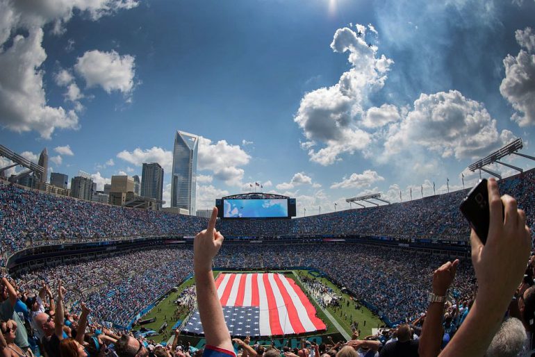 fans-cheering-in-stadium-with-American-flag-on-field